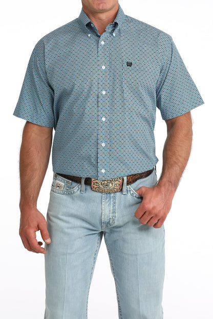man wearing a blue patterned Cinch shirt with blue jeans on a white background