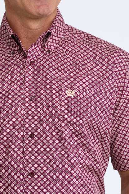 Close-up of a man wearing a patterned Cinch shirt with a visible brand logo.