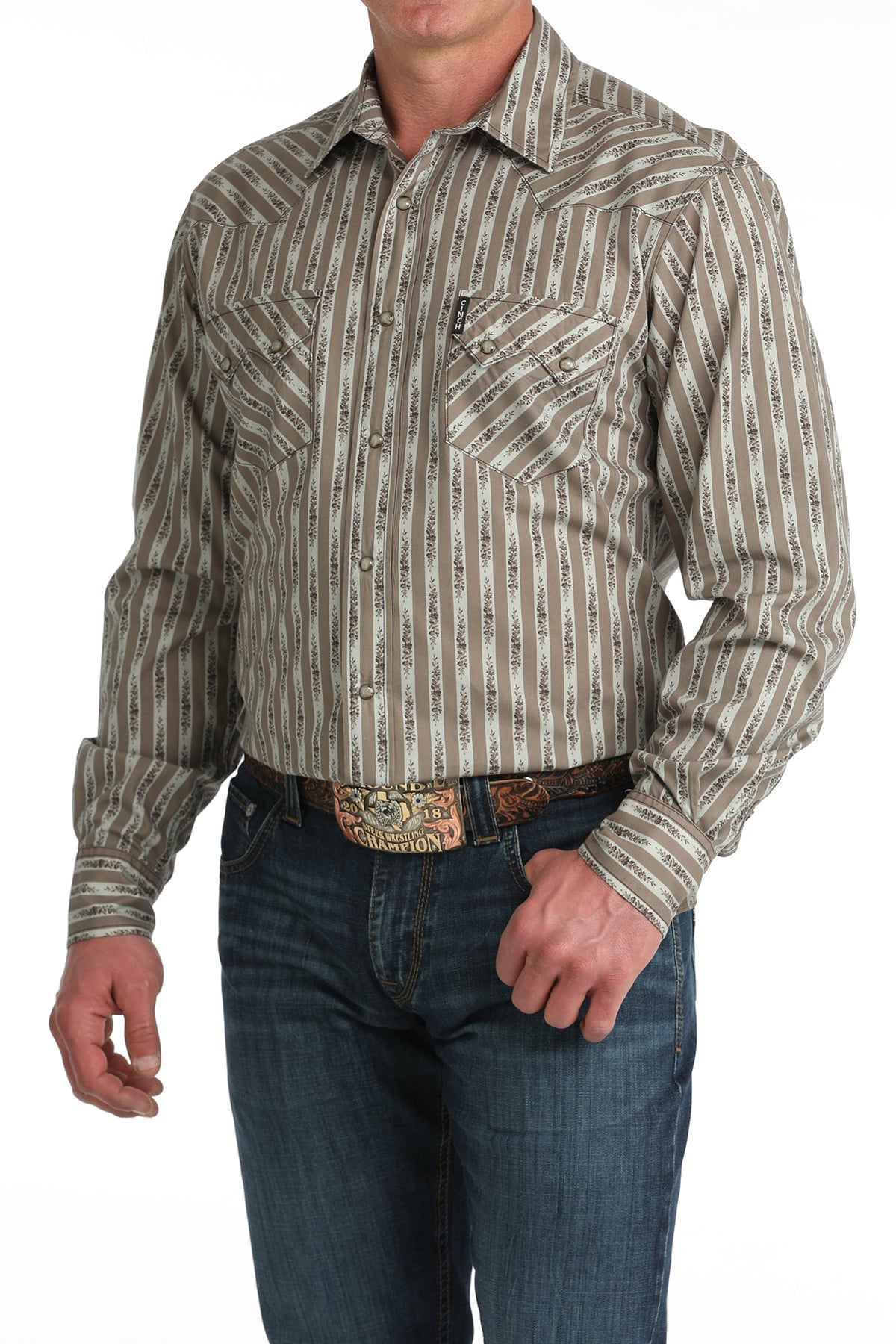 Man wearing a patterned long-sleeve 'Cinch' shirt and jeans on a white background