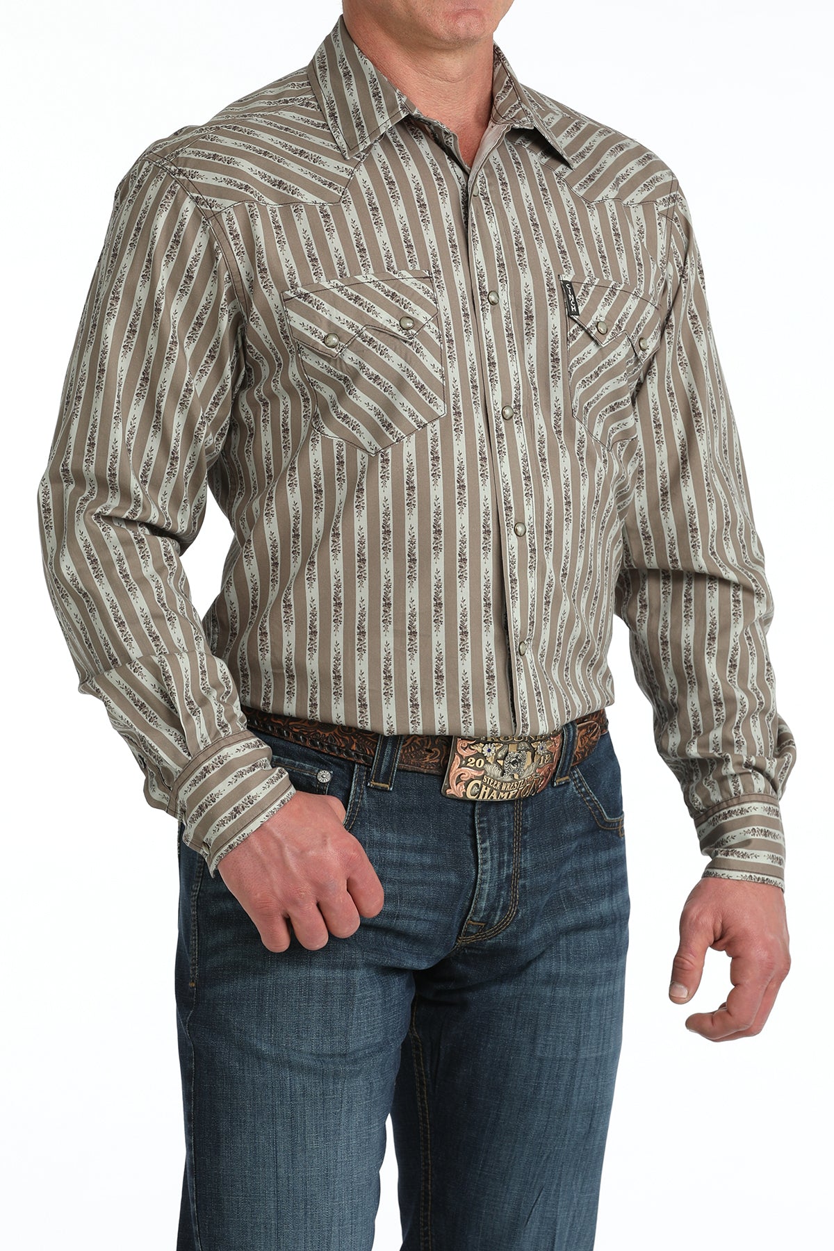 Man wearing a patterned long-sleeve 'Cinch' shirt and jeans on a white background