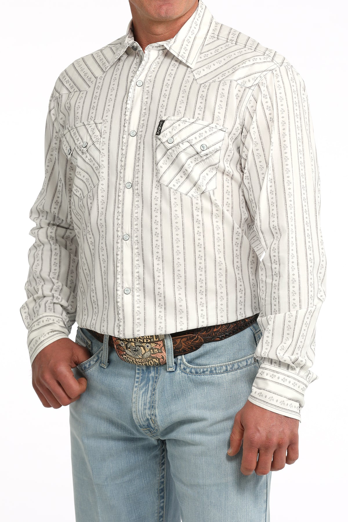 Man wearing a white striped Cinch shirt and light blue jeans on a white background
