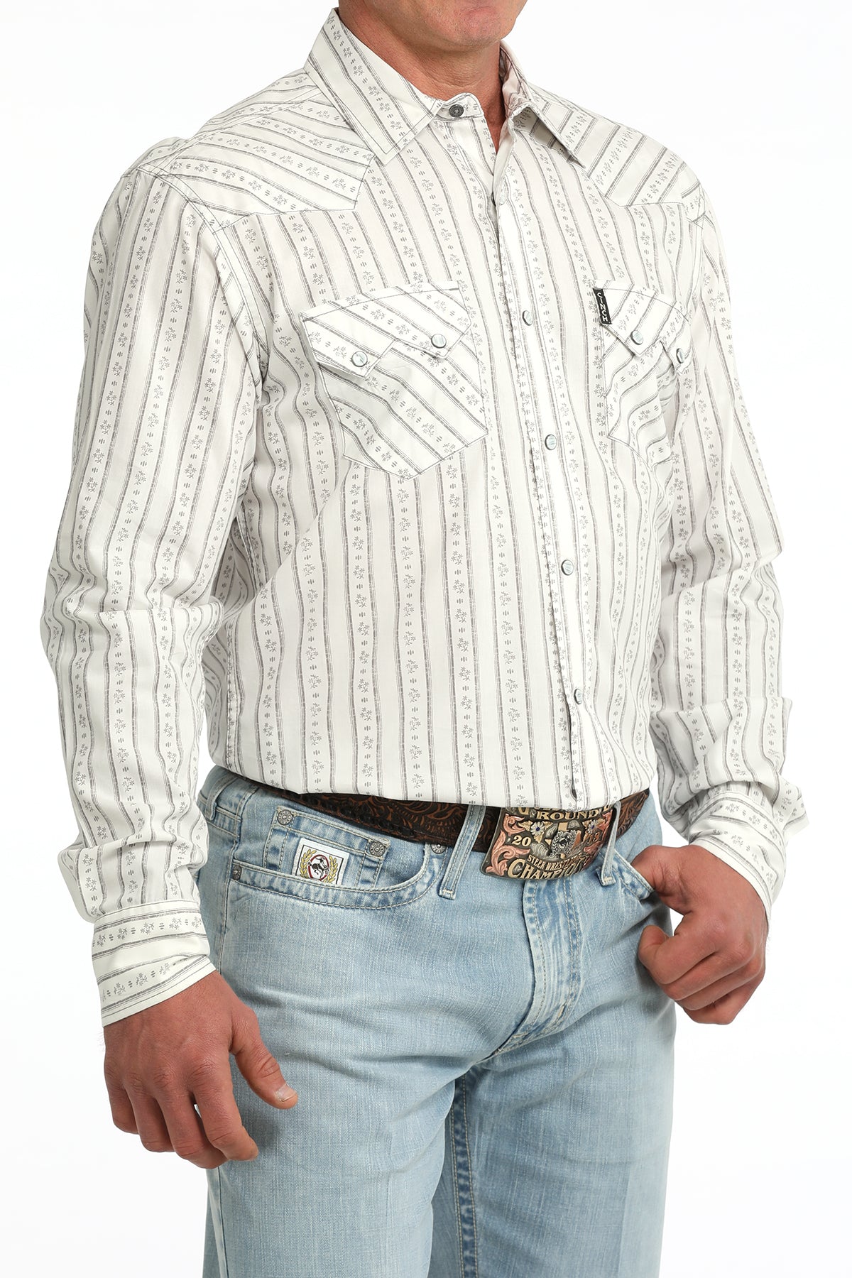 Man wearing a white striped Cinch shirt and light blue jeans on a white background