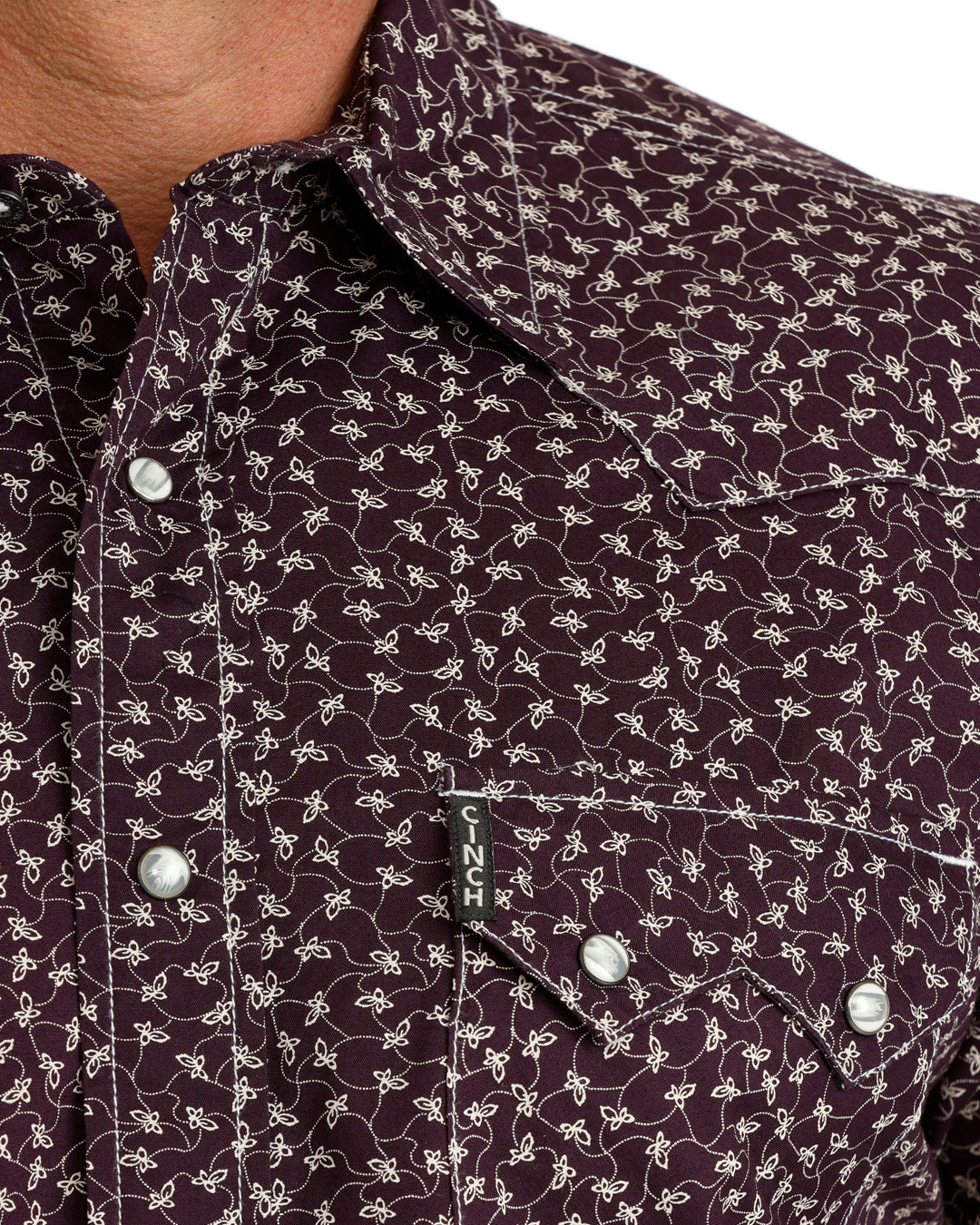 Close up of a man wearing a purple floral Cinch shirt on a white background