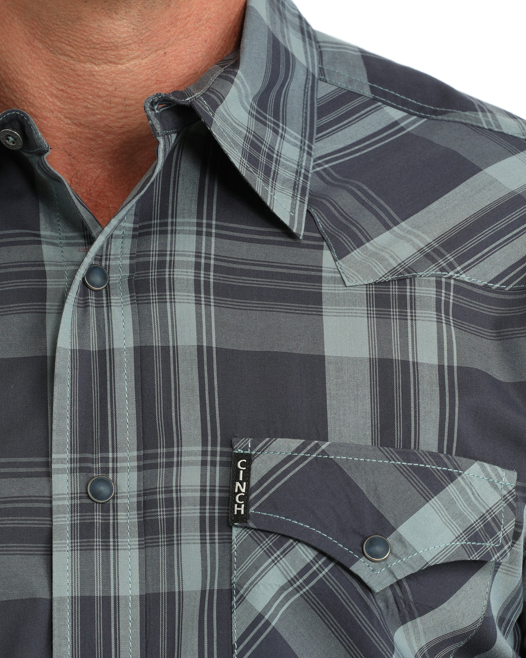 close up of a man wearing a blue plaid Cinch shirt on a white background