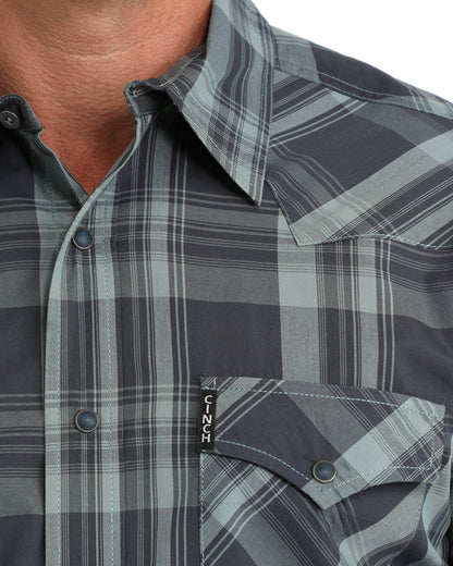 close up of a man wearing a blue plaid Cinch shirt on a white background