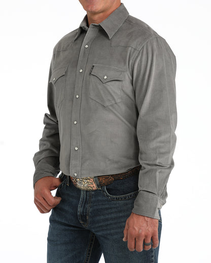 man wearing a grey corduroy Cinch shirt and blue jeans on a white background