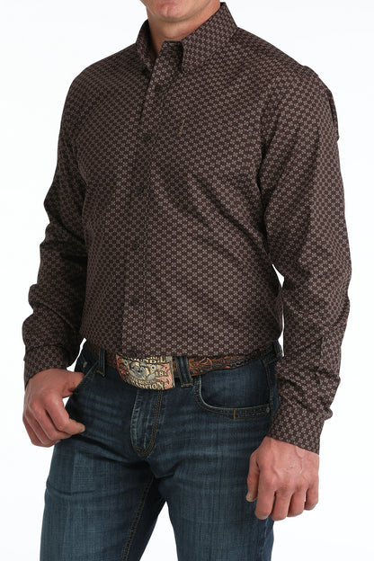 Man wearing a patterned brown 'Cinch' shirt and jeans with a belt.