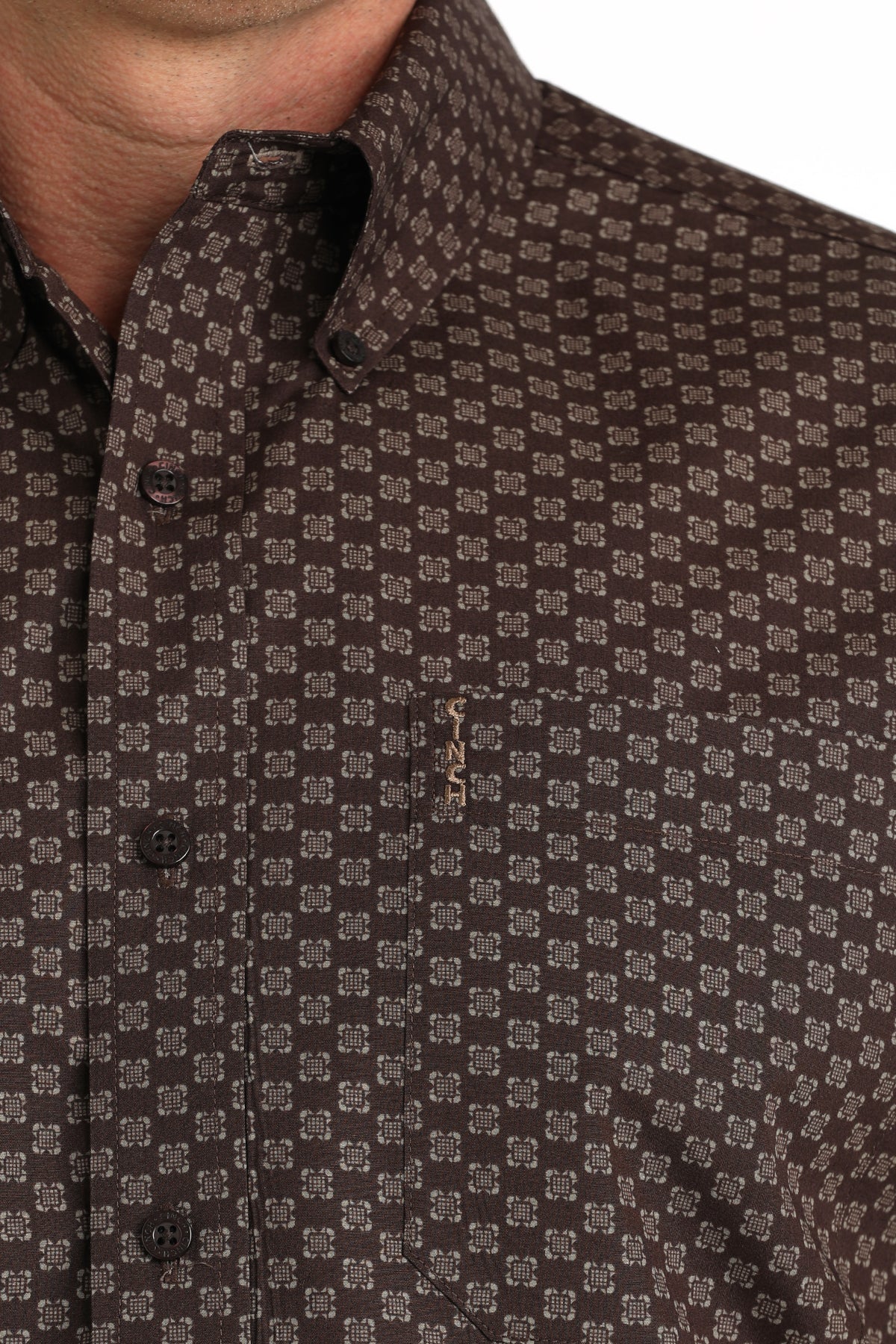 Close-up of a brown patterned 'Cinch' shirt with a collar.