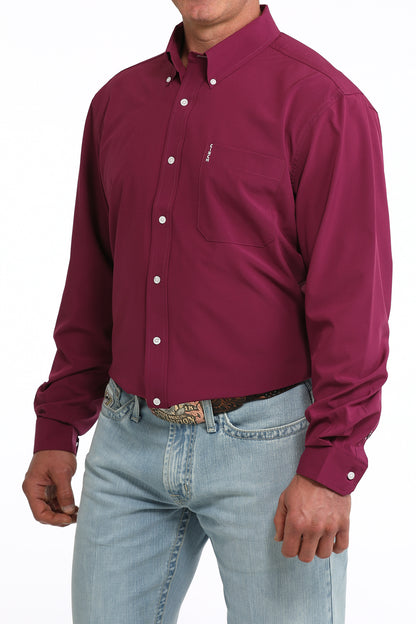 Man wearing a maroon button-up Cinch shirt and light blue jeans on a white background