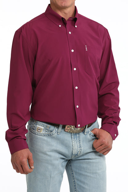 Man wearing a maroon button-up Cinch shirt and light blue jeans on a white background