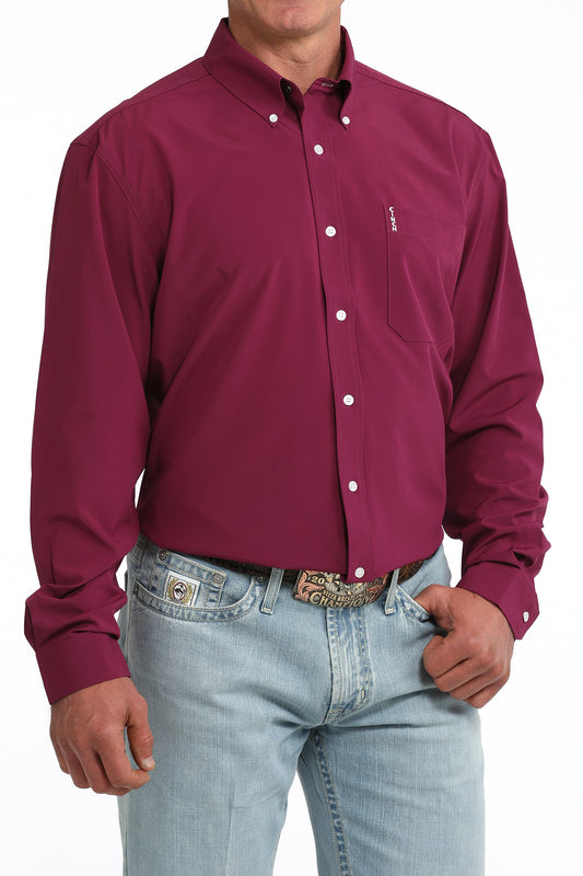 Man wearing a maroon button-up Cinch shirt and light blue jeans on a white background
