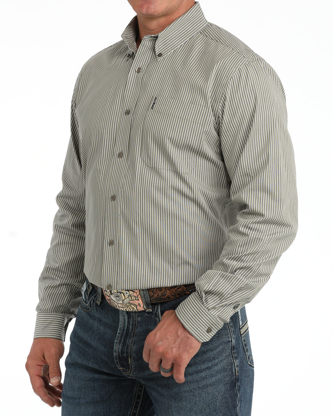 A man wearing a long-sleeve button-down Cinch shirt with thin vertical gray and white stripes, paired with blue jeans and a patterned belt, shown from the waist up against a white background.