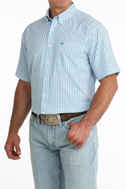 man wearing a blue printed shirt and blue jeans on a white background