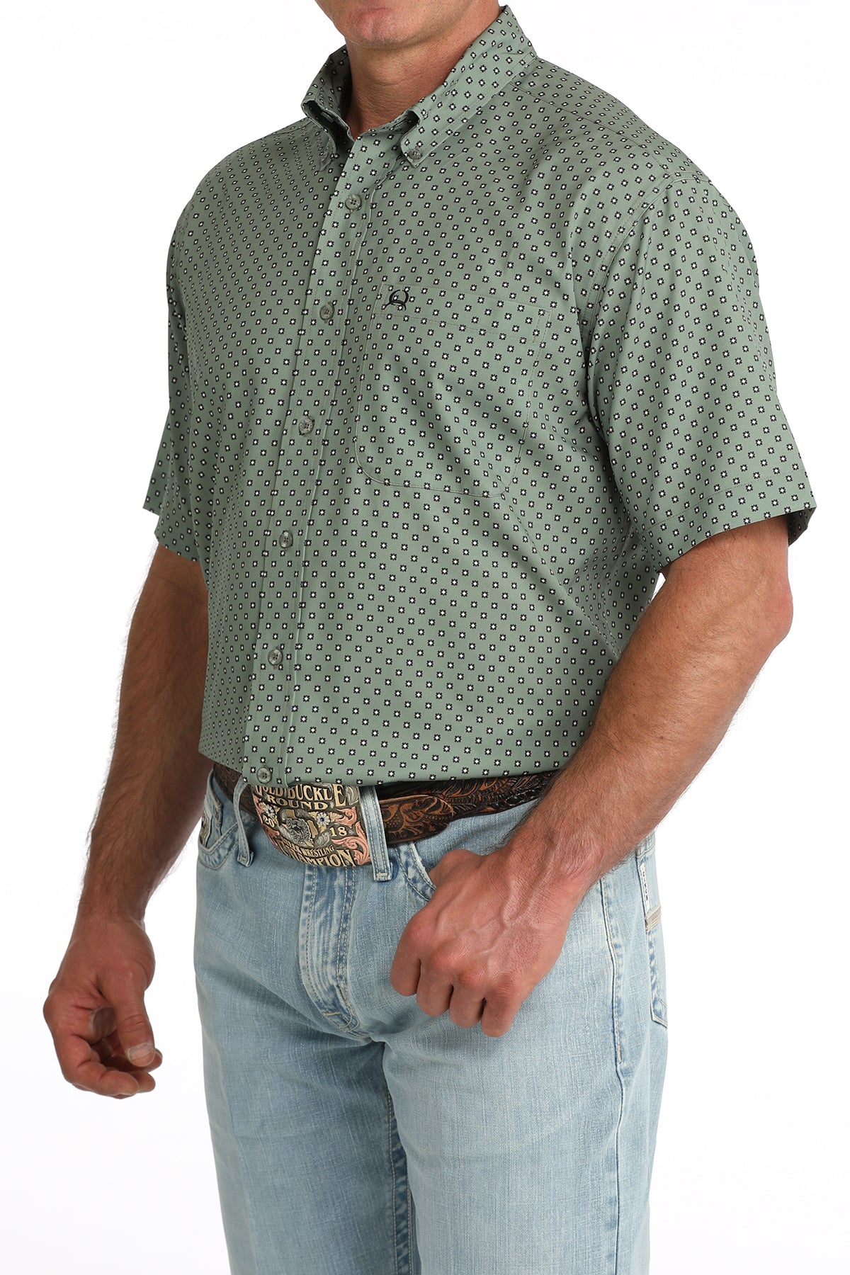 man wearing an olive green Cinch shirt and blue jeans on a white background
