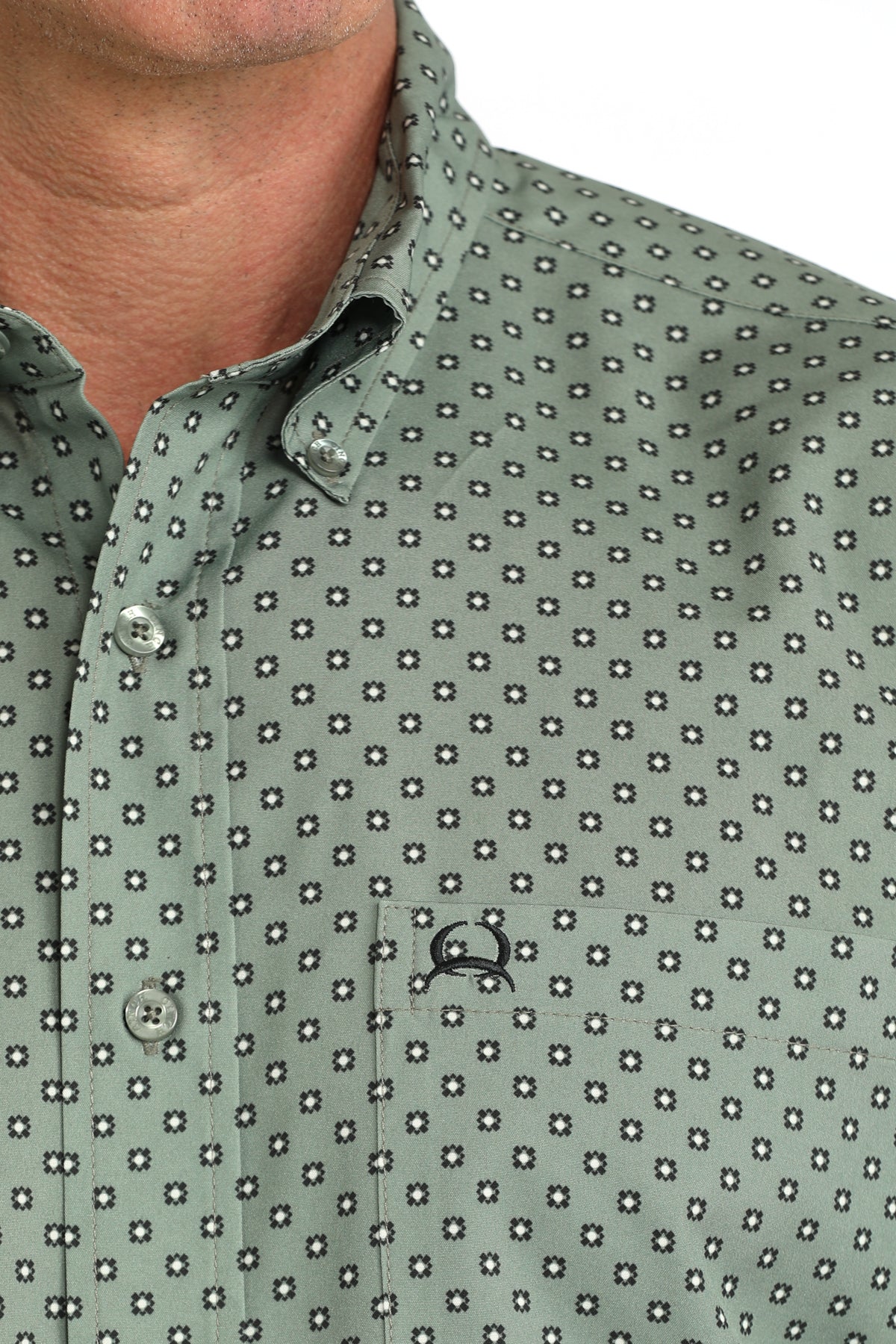 man wearing an olive green Cinch shirt on a white background