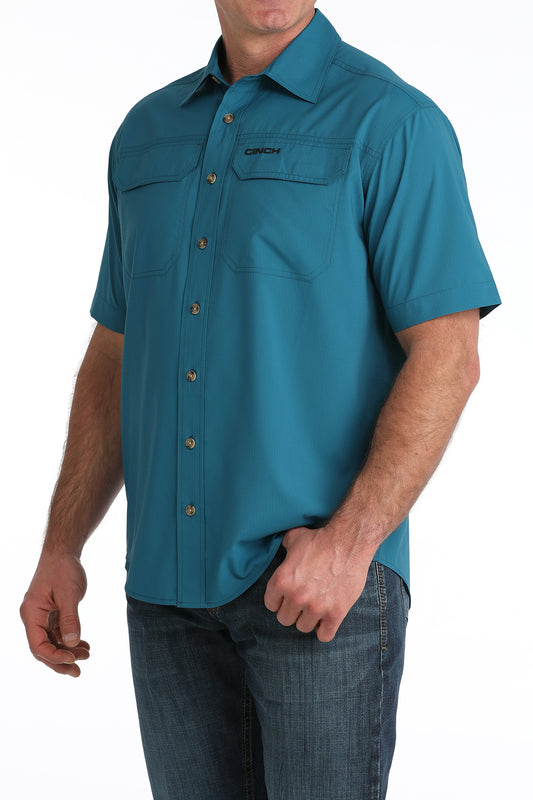 Teal short-sleeve Cinch shirt worn by a person on a white background
