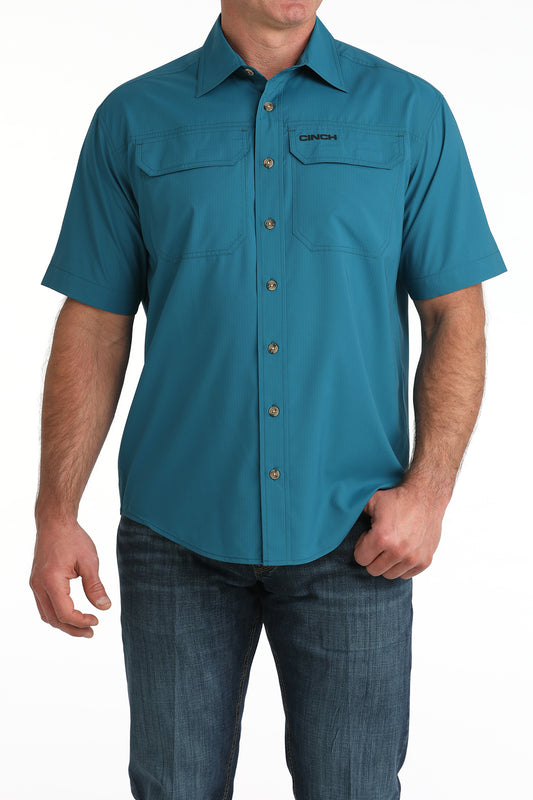 Teal short-sleeve Cinch shirt worn by a person on a white background