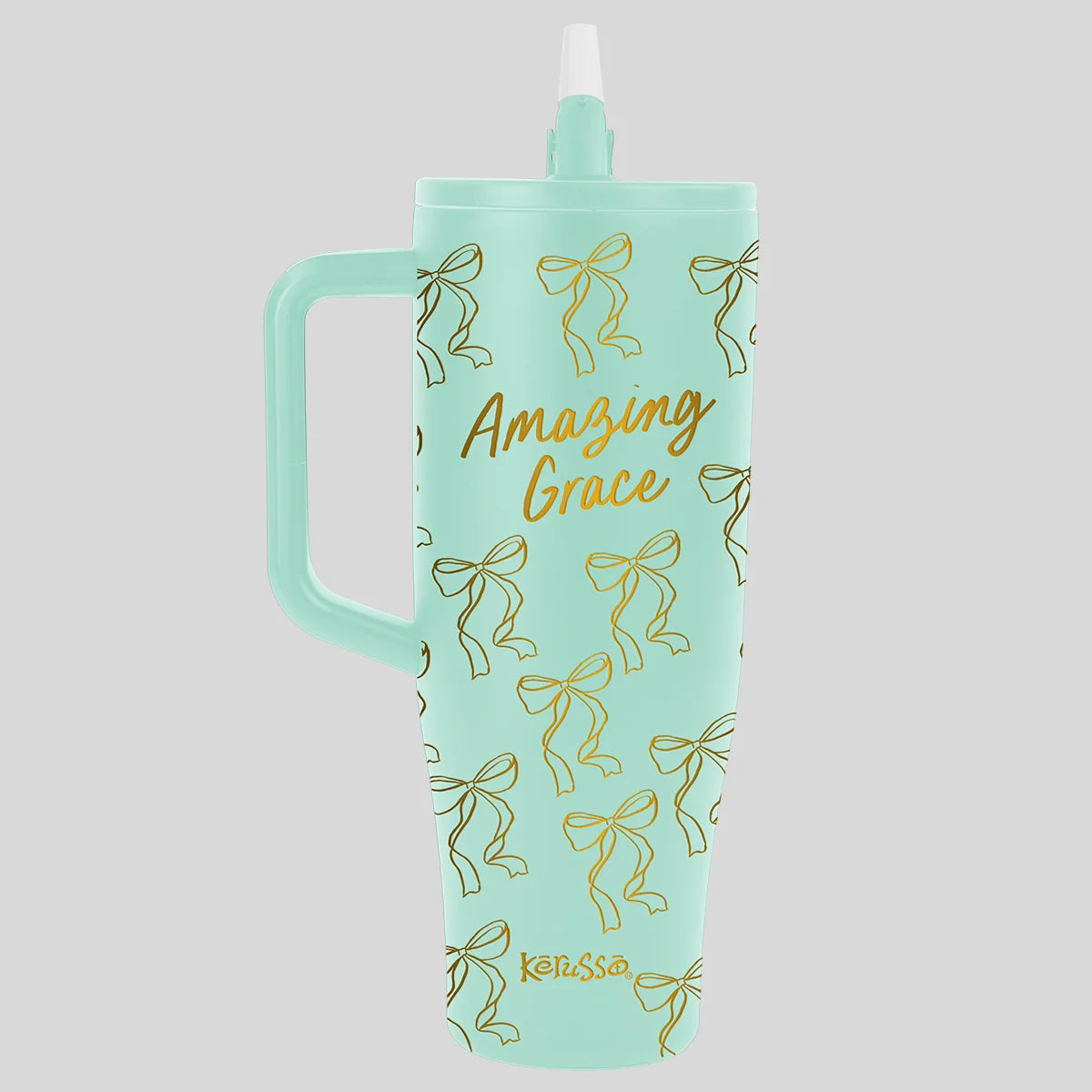 A mint green handled tumbler by Kerusso with a straw lid, decorated with gold foil bow outlines and the words 'Amazing Grace' in gold script, on a solid gray background.