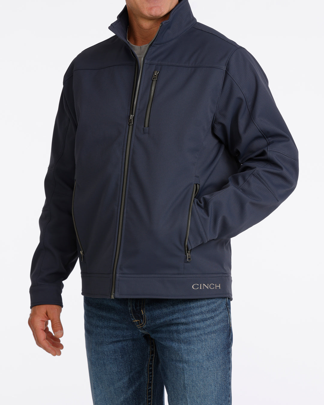 Man wearing a navy Cinch jacket and blue jeans on a white background