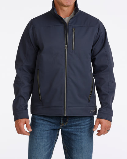 Man wearing a navy Cinch jacket and blue jeans on a white background