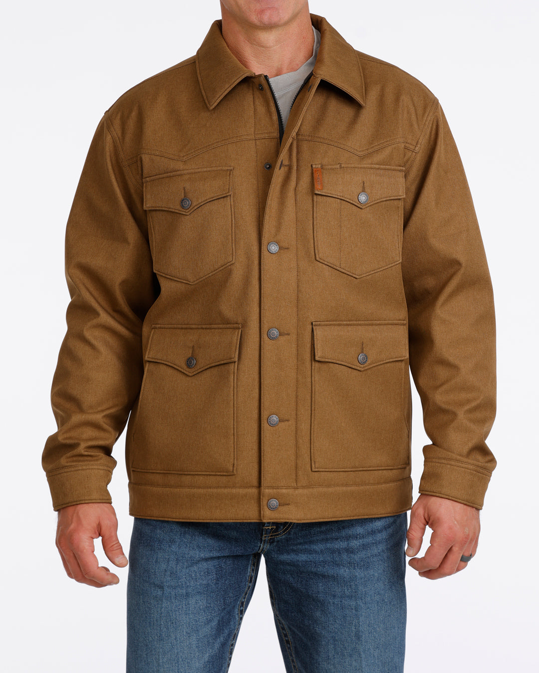 Man wearing a brown Cinch jacket and blue jeans on a white background
