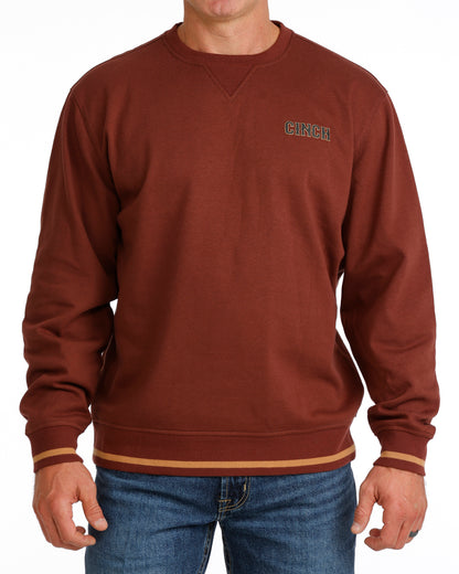 Burgundy sweatshirt with a Cinch logo on the chest worn by a person, against a white background