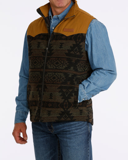 man wearing a Cinch vest with aztec design, denim shirt and blue jeans on a white background