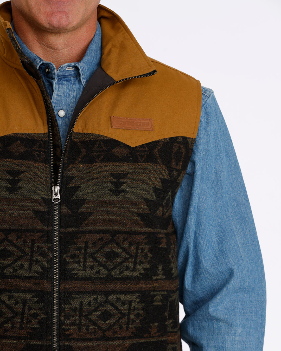 man wearing a Cinch vest with aztec design and denim shirt on a white background