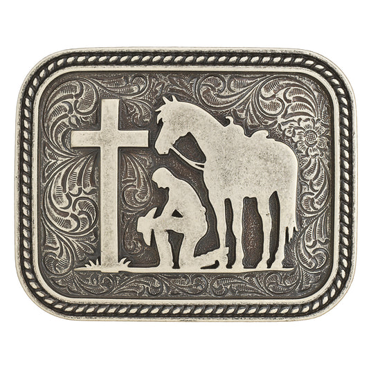 Belt buckle from Nocona with a cowboy and a horse praying by a cross on a white background