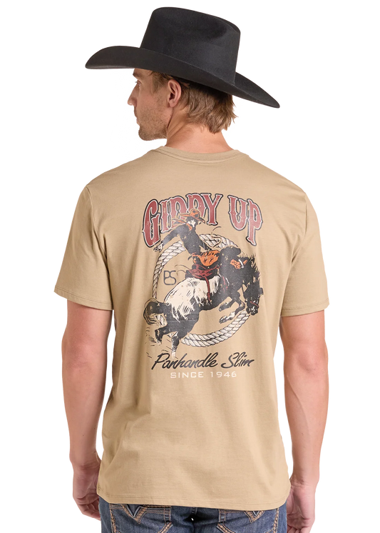 Man wearing a tan Panhandle Slim t-shirt with a bronc rider on it, blue jeans and a black cowboy hat on a white background