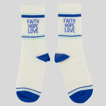 A pair of white crew socks from Kerusso with blue accents, featuring the words 'FAITH HOPE LOVE' printed in blue on the upper leg, set against a solid light gray background.