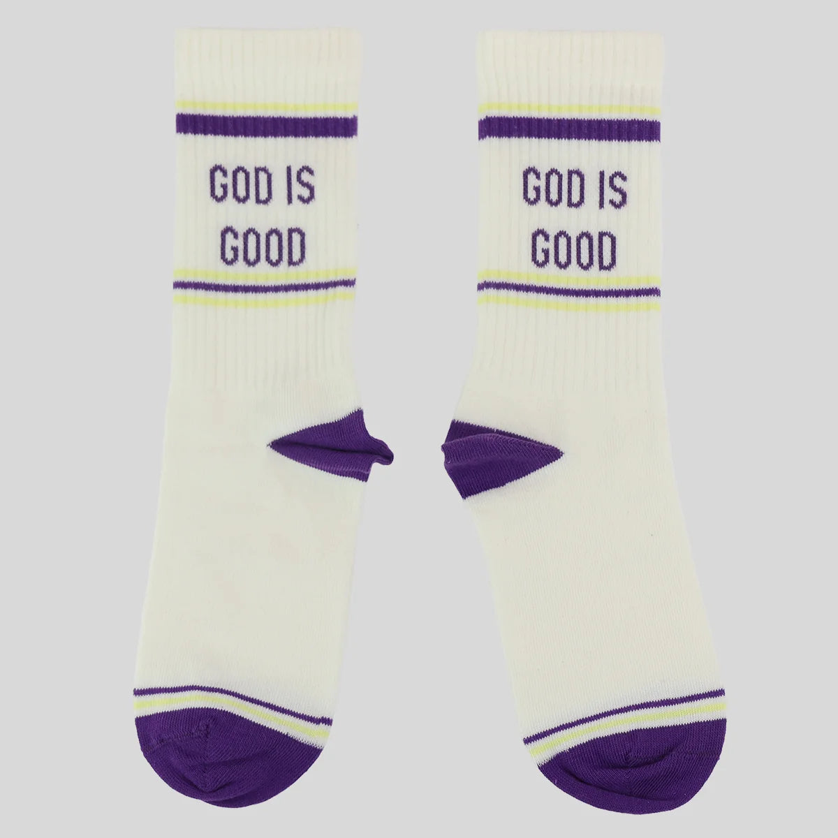 A pair of white crew socks from Kerusso with purple and light green accents, featuring the text 'GOD IS GOOD' printed in purple on the upper leg.