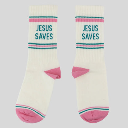 A pair of off-white crew socks from Kerusso with pink heels and toes, featuring teal and pink stripes near the cuff with the text 'JESUS SAVES' printed in teal. Photographed on a solid light gray background.