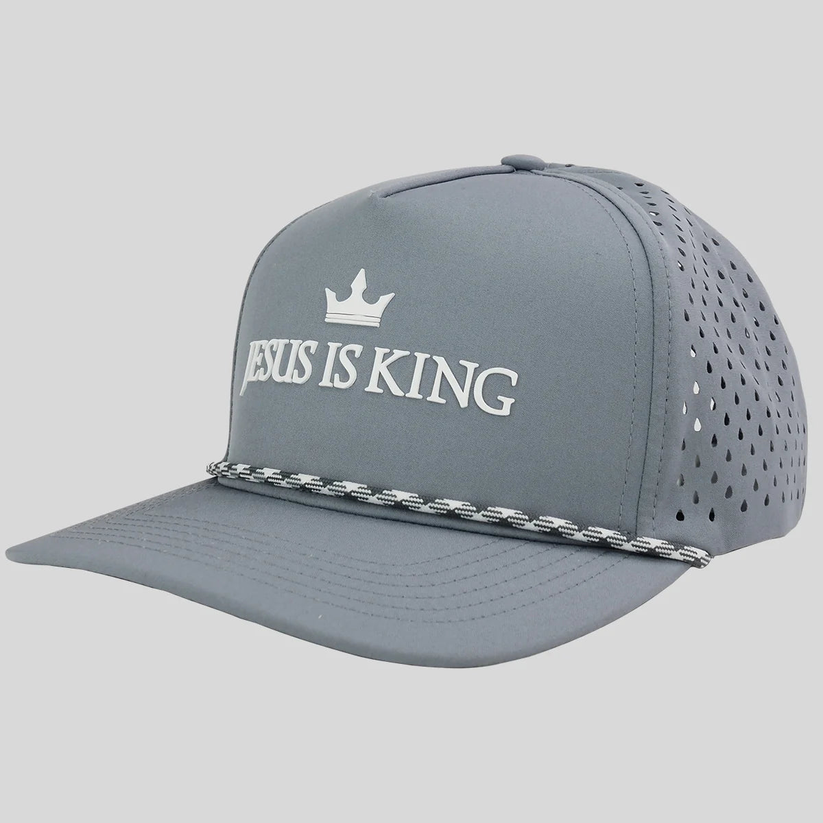 A gray baseball cap from Kerusso  with white embroidered text reading 'JESUS IS KING' and a small crown above it, plus a silver chain detail across the brim, shown on a light gray background.
