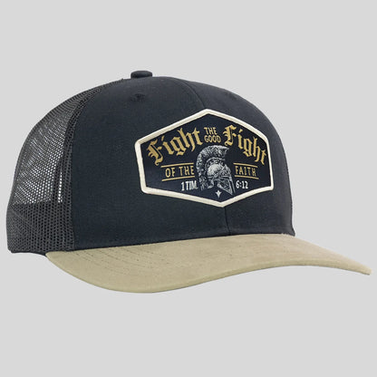 A black trucker hat from Kerusso with a beige visor and black mesh back panels, featuring a large embroidered patch on the front with the text 'Fight the Good Fight of the Faith' and a helmet graphic.