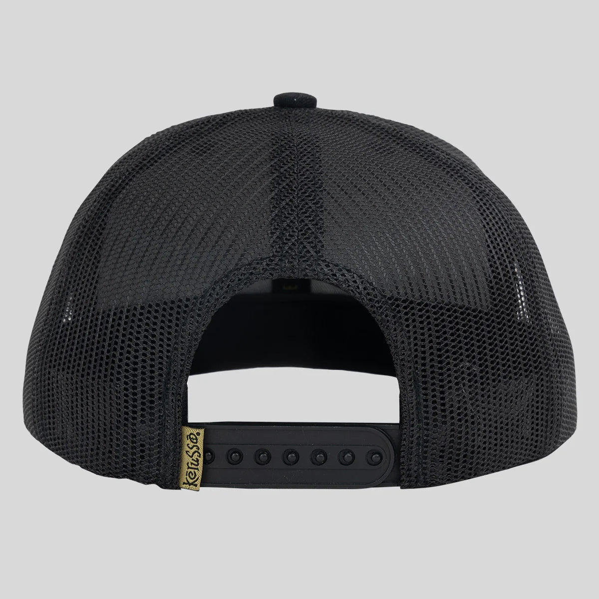Kerusso black trucker hat shown from the back, featuring a black mesh back, black adjustable snapback strap, and a small gold brand tag.