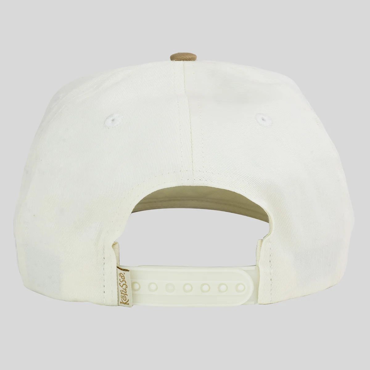 Back view of a white baseball cap from Kerusso with an adjustable snapback strap and a small gold brand tag, shown on a light gray background.