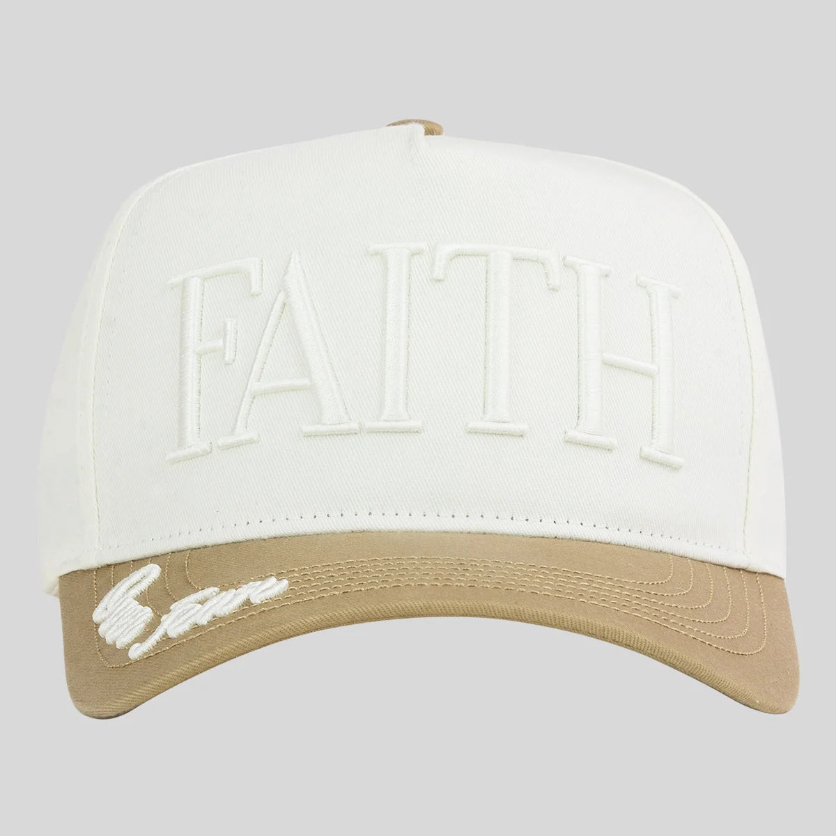 A structured baseball cap from Kerusso with a white crown featuring embossed 'FAITH' lettering and a tan curved brim with white script embroidery, shown against a solid gray background.
