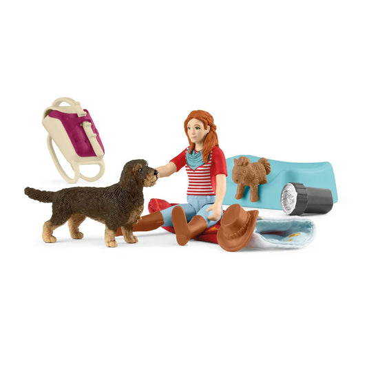 Schleich toy figure of a person with a dog and camping gear on a white background