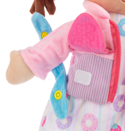 Close-up of a plush Ganz toy with pink arm and purple vest on a white background