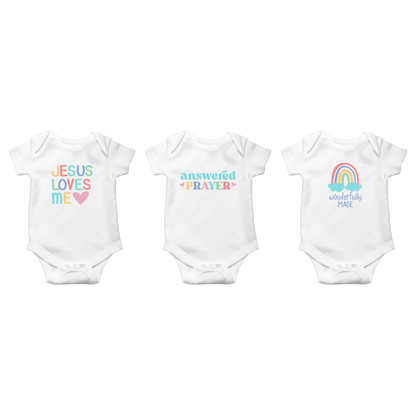 Three Ganz white baby onesies with colorful text and graphics on a white background
