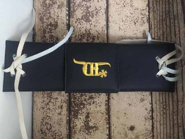 Black bull rope pad by crooked horn with a cover on a wood background