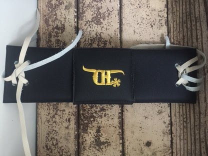 Black bull rope pad by crooked horn with a cover on a wood background