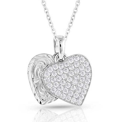 Heart-shaped Montana Silversmiths silver pendant with clear stones on a white background