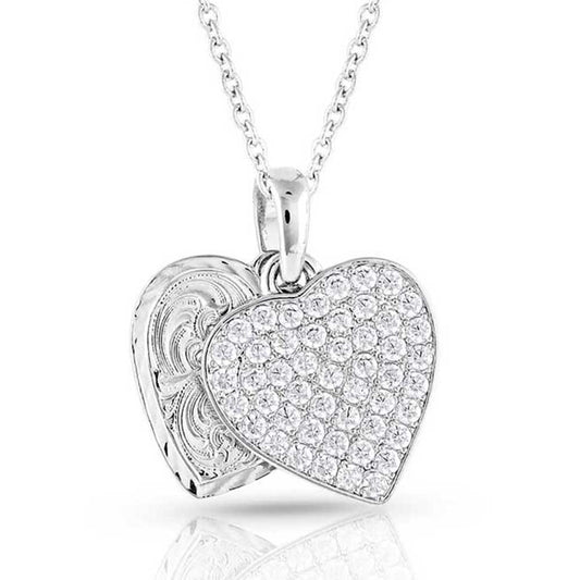 Heart-shaped Montana Silversmiths silver pendant with clear stones on a white background