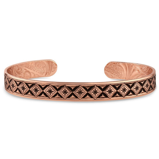 Copper Montana Silversmiths bracelet with intricate patterns on a white background