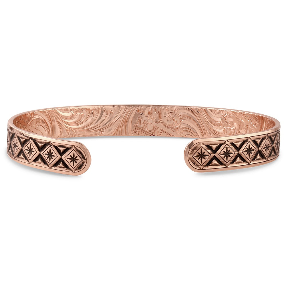 Copper Montana Silversmiths bracelet with intricate patterns on a white background