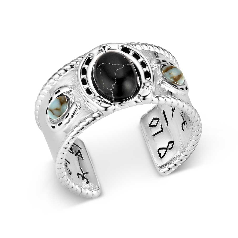 Silver Montana Silversmiths ring with black stone and turquoise accents on a white background