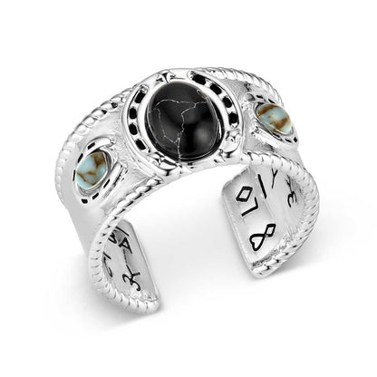 Silver Montana Silversmiths ring with black stone and turquoise accents on a white background