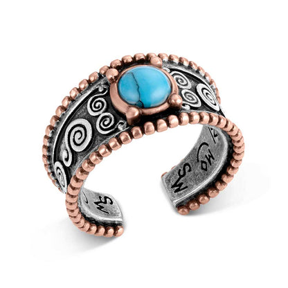 Montana Silversmiths ring with silver and bronze and a turquoise gem on a white background
